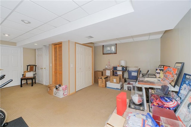 finished below grade area with carpet floors, visible vents, and a paneled ceiling