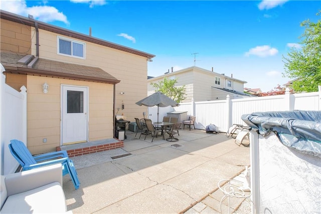 back of property featuring a fenced backyard, a shingled roof, outdoor dining area, and a patio area
