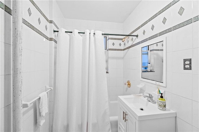 full bathroom featuring tile walls, shower / bath combo with shower curtain, and vanity