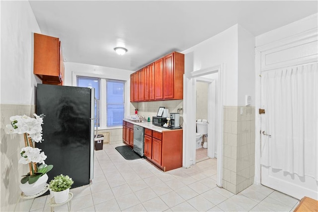 kitchen with tile walls, light tile patterned flooring, light countertops, dark brown cabinets, and appliances with stainless steel finishes