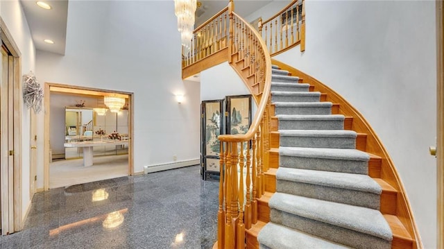 staircase featuring baseboards, a high ceiling, recessed lighting, a baseboard radiator, and granite finish floor