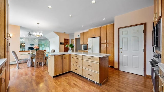kitchen with light countertops, light wood finished floors, a kitchen island, and white refrigerator with ice dispenser