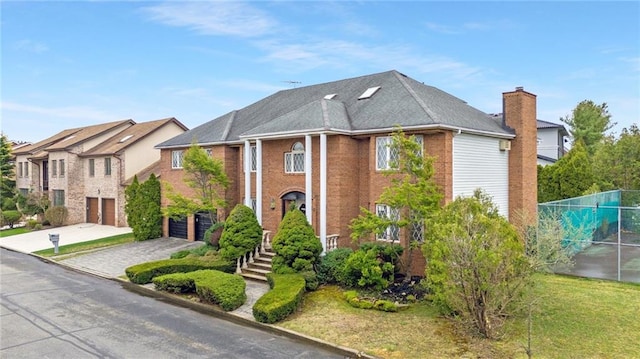 greek revival inspired property featuring a garage, fence, and driveway