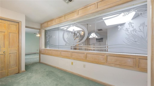 bathroom featuring a skylight, visible vents, and baseboard heating