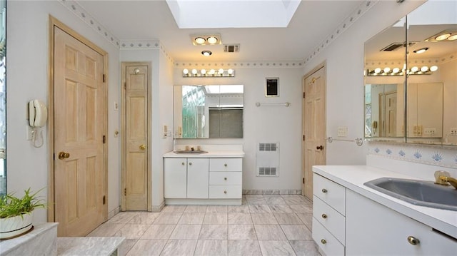 bathroom featuring a skylight, marble finish floor, a sink, and visible vents