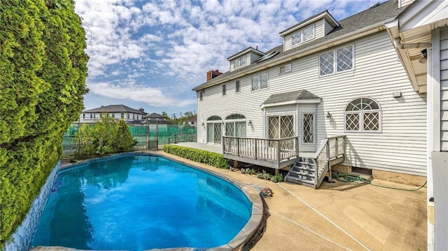 view of pool with a deck, a patio area, a fenced in pool, and fence