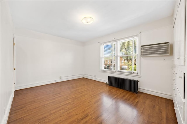 1933 E 28th St, Brooklyn, NY 11229 - unfurnished room with radiator, wood finished floors, a wall mounted air conditioner, and baseboards