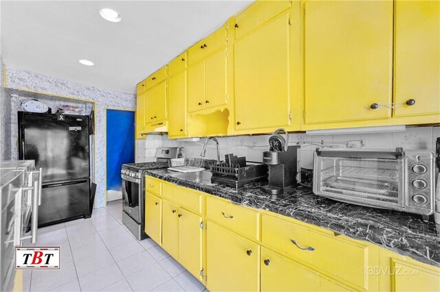 2052 E 28th St, Brooklyn, NY 11229 - kitchen featuring gas stove, freestanding refrigerator, under cabinet range hood, dark countertops, and recessed lighting