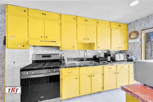 2052 E 28th St, Brooklyn, NY 11229 - kitchen with stainless steel range with gas cooktop, a sink, under cabinet range hood, wallpapered walls, and dark countertops