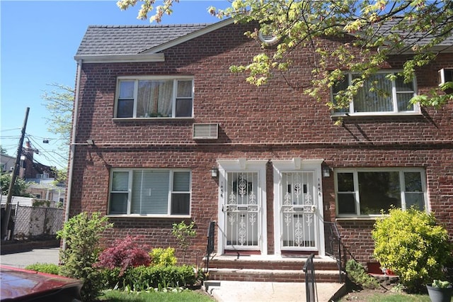 view of front of house featuring brick siding and a shingled roof