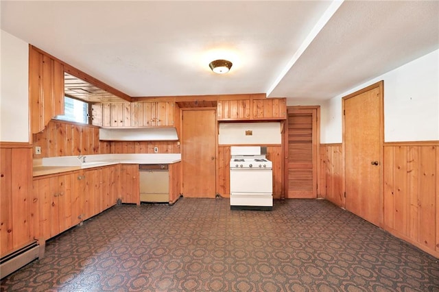 kitchen featuring white range with gas stovetop, wood walls, wainscoting, light countertops, and a baseboard radiator