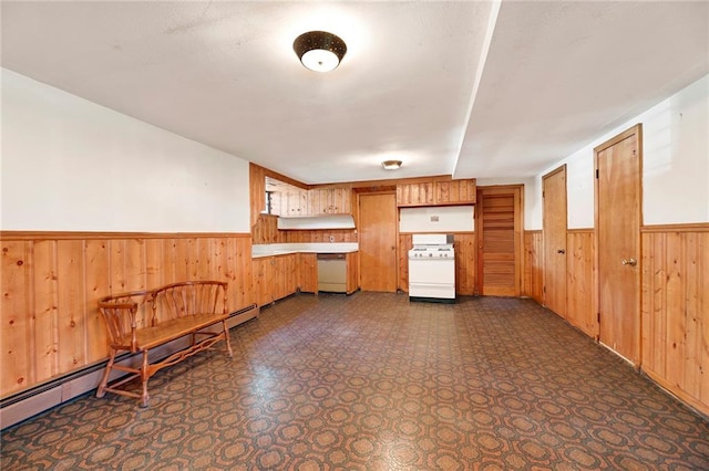 kitchen with a baseboard heating unit, white appliances, wood walls, and wainscoting