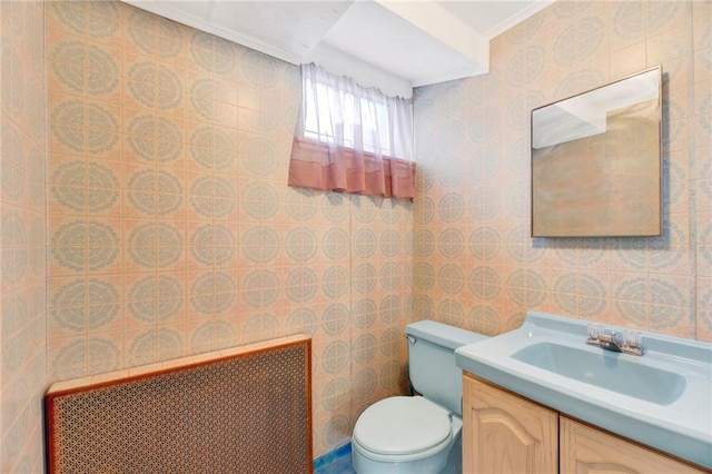 bathroom featuring vanity, toilet, and radiator