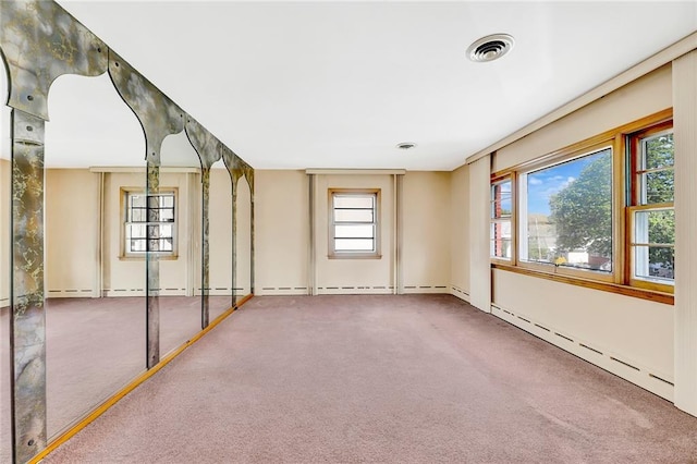 carpeted spare room featuring visible vents and a baseboard radiator