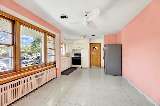 kitchen with white range with gas cooktop, radiator, freestanding refrigerator, under cabinet range hood, and a ceiling fan