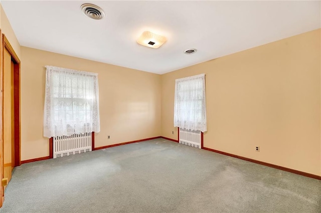unfurnished bedroom with radiator, baseboards, carpet flooring, and visible vents