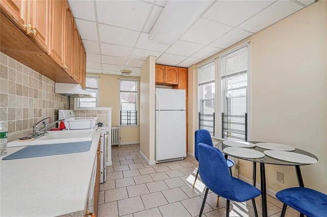 222 Albemarle Rd, Brooklyn, NY 11218 - kitchen with freestanding refrigerator, range, light countertops, light tile patterned floors, and under cabinet range hood