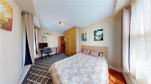bedroom featuring baseboards and dark wood finished floors