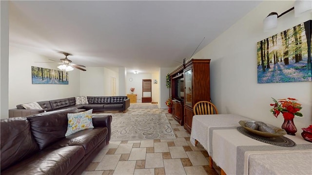 living area with a ceiling fan and stone finish flooring