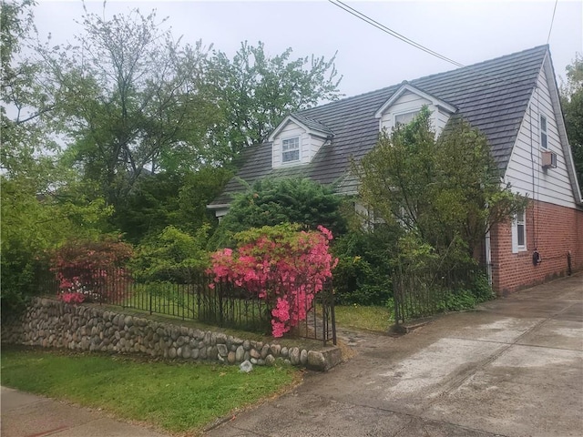 view of home's exterior with brick siding and fence