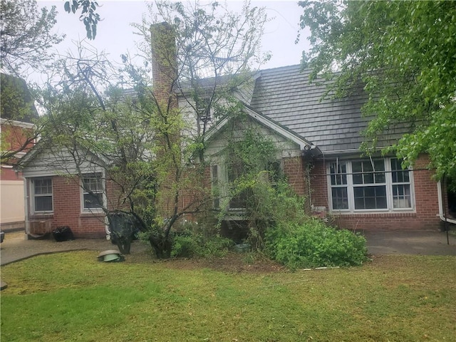 view of property exterior featuring a yard and brick siding