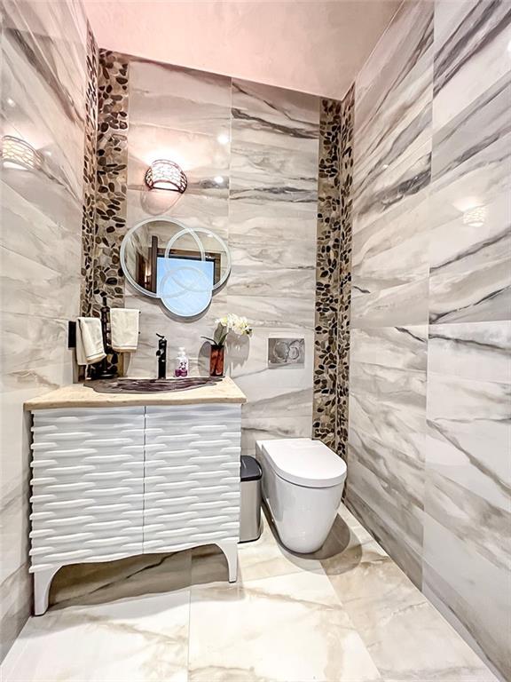 166 Pinewood Ave, Staten Island, NY 10306 - bathroom with tile walls, marble finish floors, vanity, and toilet