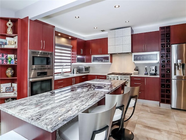 166 Pinewood Ave, Staten Island, NY 10306 - kitchen featuring appliances with stainless steel finishes, open shelves, a sink, reddish brown cabinets, and a kitchen breakfast bar
