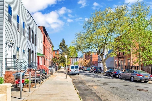 view of street with street lighting, curbs, sidewalks, and a residential view