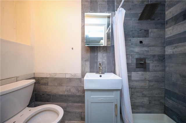 436 76th St, Brooklyn, NY 11209 - bathroom with tile walls, toilet, a shower stall, vanity, and wainscoting