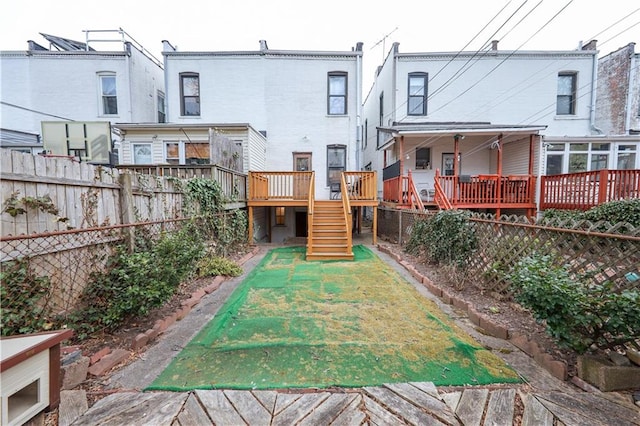 436 76th St, Brooklyn, NY 11209 - back of property featuring a fenced backyard, stairs, and a deck