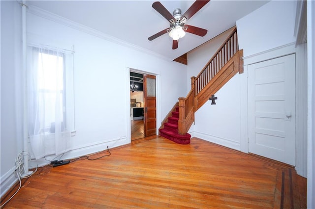 436 76th St, Brooklyn, NY 11209 - unfurnished living room with a ceiling fan, stairs, wood finished floors, crown molding, and baseboards
