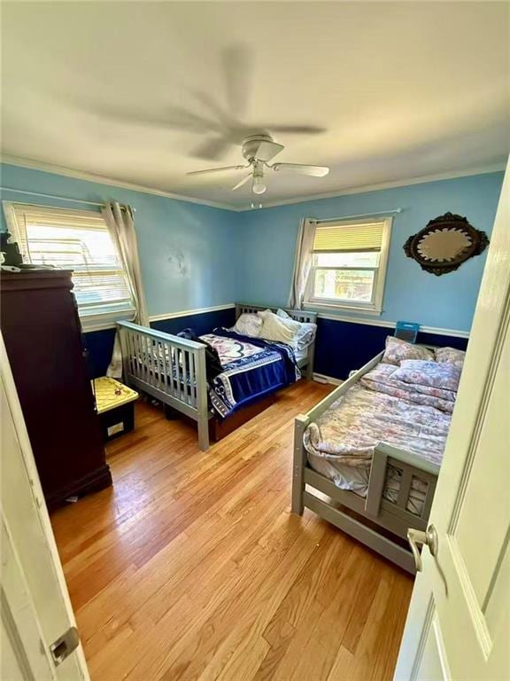 bedroom with ornamental molding, a ceiling fan, and wood finished floors