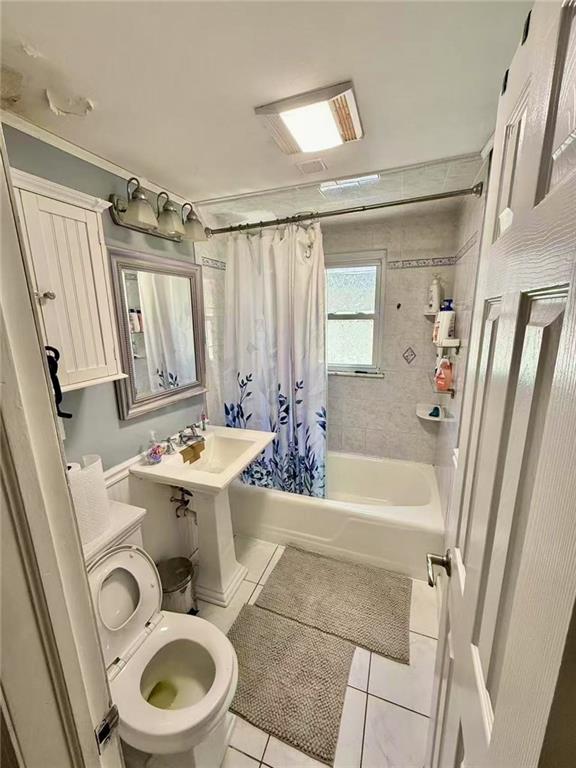bathroom featuring toilet, tile patterned flooring, and shower / tub combo