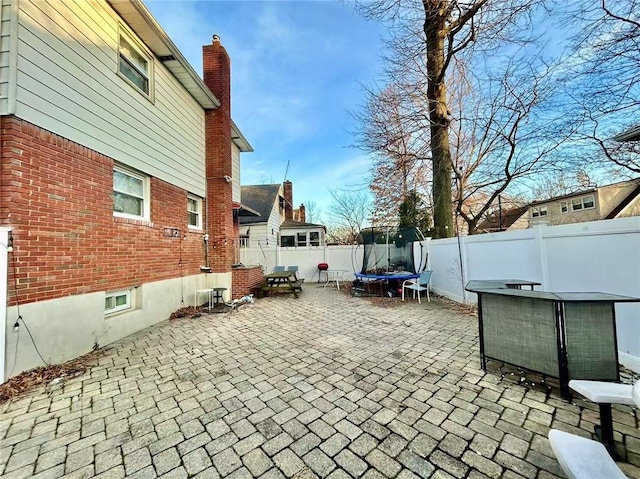 view of patio / terrace with a trampoline and a fenced backyard