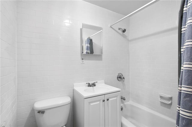 bathroom with tile walls, shower / bath combo, vanity, and toilet