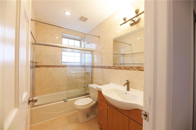 69 Bay 20th St Unit 3A, Brooklyn, NY 11214 - full bath featuring tile walls, vanity, shower / bath combination with glass door, toilet, and tile patterned flooring
