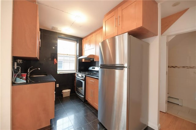 69 Bay 20th St Unit 3A, Brooklyn, NY 11214 - kitchen with appliances with stainless steel finishes, a sink, dark countertops, a baseboard radiator, and under cabinet range hood