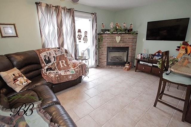 living area with tile patterned flooring and a brick fireplace
