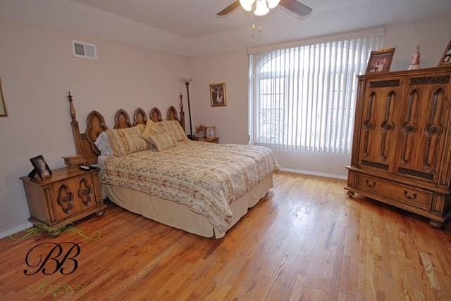 bedroom featuring ceiling fan, baseboards, light wood-type flooring, and visible vents