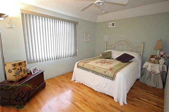 bedroom featuring ceiling fan, visible vents, and wood finished floors