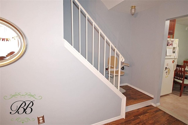 stairway with baseboards and wood finished floors