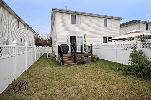 rear view of house with central AC unit, a deck, a gazebo, and a fenced backyard