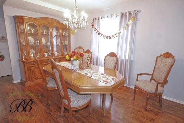 dining area with wood finished floors, baseboards, and a notable chandelier