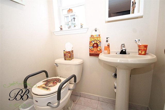 bathroom featuring tile patterned flooring, toilet, and baseboards