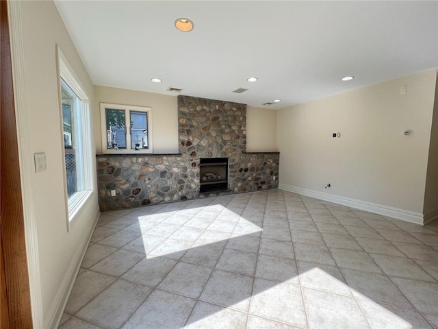 unfurnished living room with baseboards, recessed lighting, a stone fireplace, and light tile patterned floors