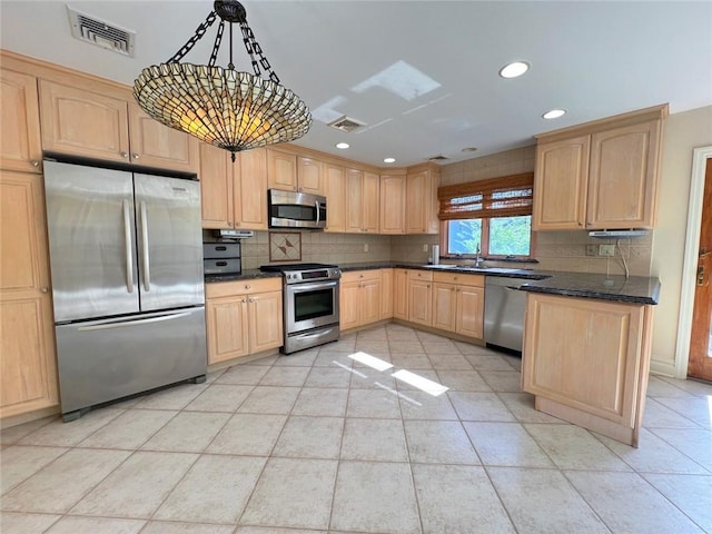 kitchen with appliances with stainless steel finishes, light brown cabinets, backsplash, light tile patterned flooring, and recessed lighting