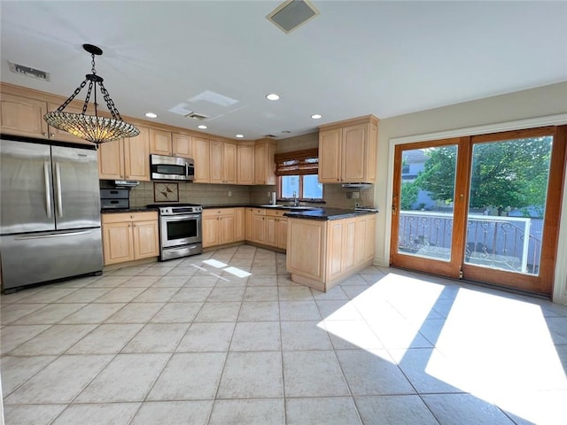kitchen featuring appliances with stainless steel finishes, dark countertops, light brown cabinetry, light tile patterned flooring, and recessed lighting
