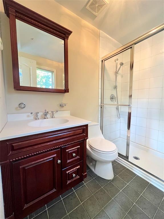 full bathroom featuring a shower stall, tile patterned floors, toilet, and vanity