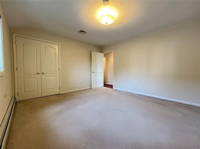 unfurnished bedroom featuring a baseboard radiator, light carpet, a closet, and baseboards