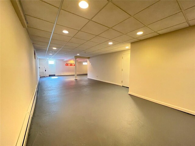 basement with recessed lighting, baseboards, and a paneled ceiling